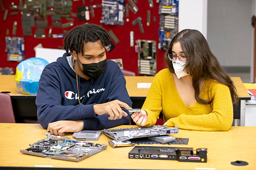 一个女学生和一个男学生在讨论计算机硬件.