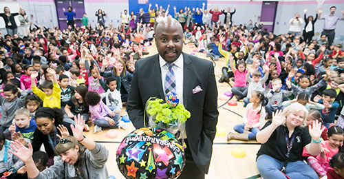 Troy Todd principal of the year in gymnasium surrounded by students and staff