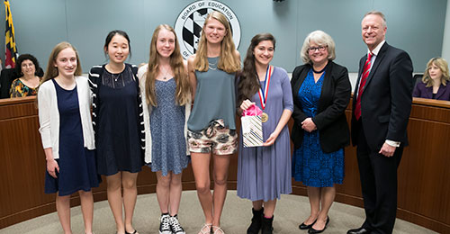 Video winners standing with Board Chairman Cynthia Vaillancourt and Dr. Michael J. Martirano