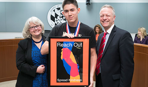 John Browder standing with Board Chairman Cynthia Vaillancourt and Dr. Michael J. Martirano