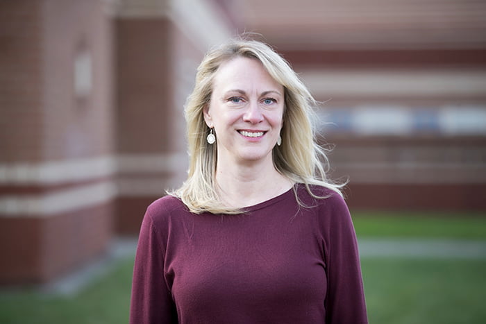 Kathy Kirn standing outside of a school