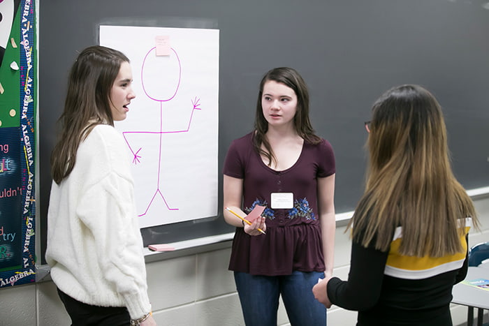 Three female high school students collaborating.