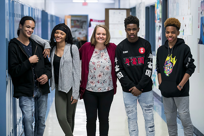 Principal Chrobak with her students inside the school building.