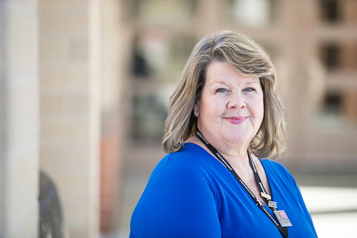 A close-up of Suzanne McMurtray standing in front of Homewood Center.