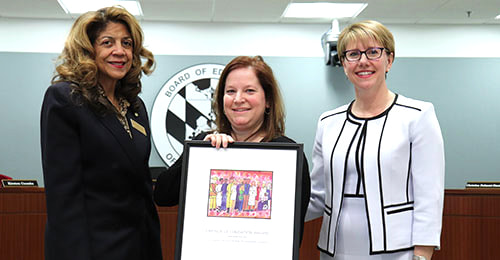 Ms. Engle receiving her award from Board of Education Chair Mavis Ellis and Deputy Superintendent Karalee Turner-Little