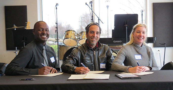 HCPSS Music Coordinator Terry Eberhardt, Triadelphia Ridge Elementary School Principal Tiffany Tresler and Bach to Rock Site Director Samir Moussa signing the partnership documents.