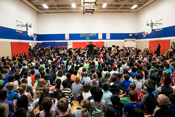 Students gathered in an auditorium listening to a speaker.