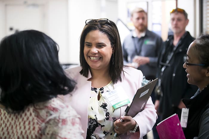 Ella Bradley smiles while interacting with others at an event.