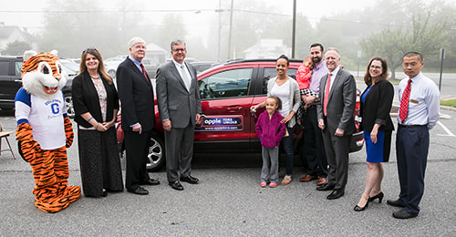 Superintendent Michael J. Martirano; members of the BOE; HCPSS Teacher of the Year Sylvia Hennessie and her family; and representatives from Apple Ford stand around Mrs. Hennessie's new vehicle.