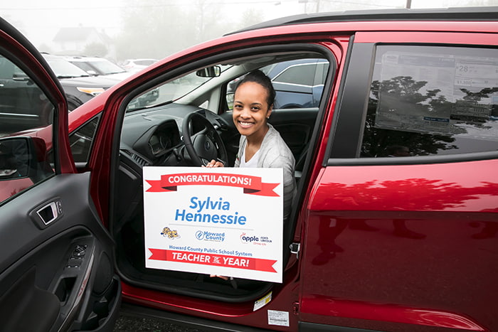 HCPSS Teacher of the Year Sylvia Hennessie sitting inside her new Ford EcoSport.