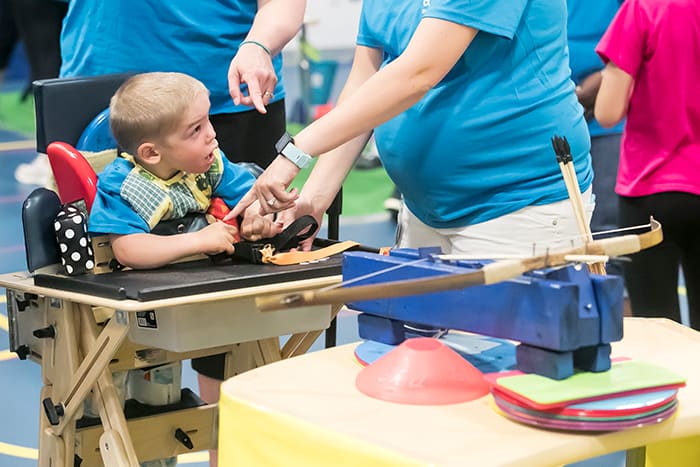 A young male student at Cedar Lane learns how to play an adapted game.