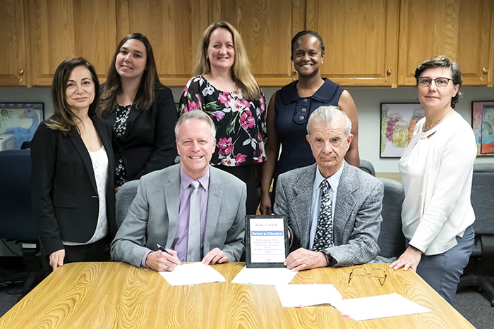 HCPSS Superintendent Matirano joins several HCPSS staff and representatives from the Italian Embassy hold a plaque commemorarting their partnership.