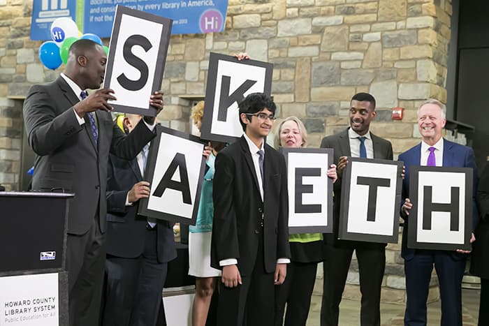 HCPSS Superintendent Matirano and others hold signs spelling out the name Saketh.