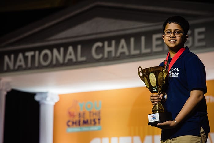 You Be the Chemist Challenge Winner Anurag Sodhi holds a trophy.