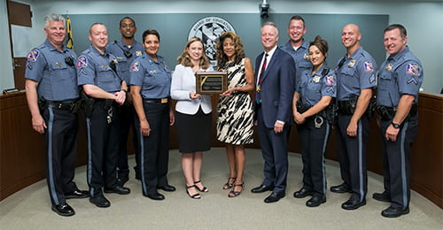 A group holds a plaque.