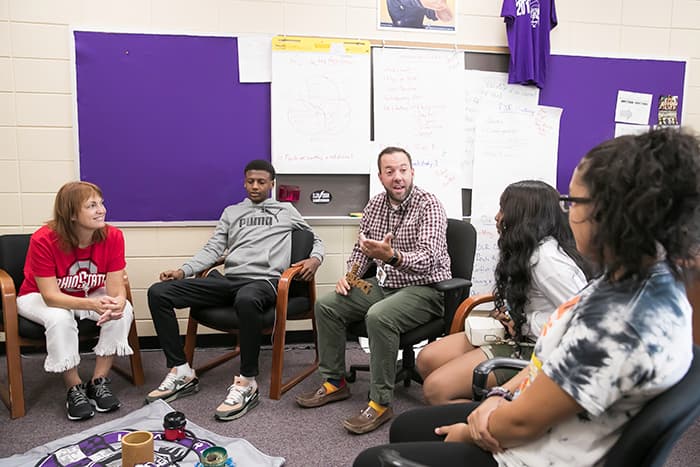 Kenny Porritt speaking with a group of students.