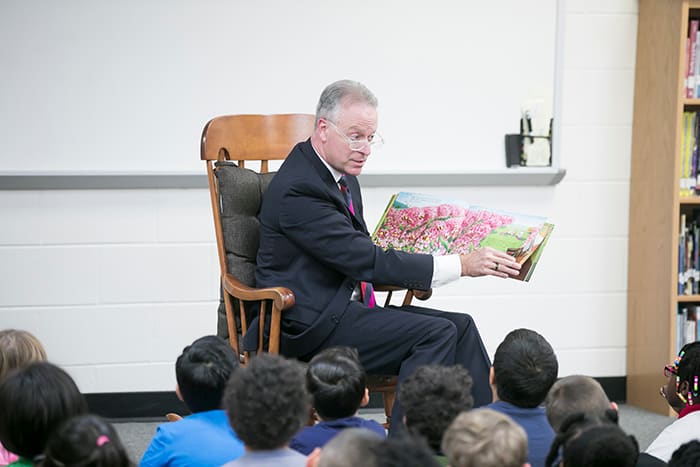Dr. Martirano reading to a group of students.