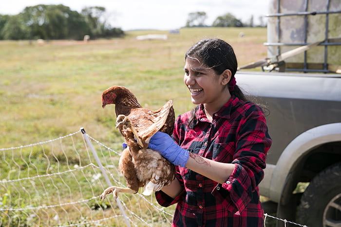 Female student holding a chicken.