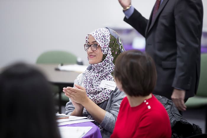 A woman wearing a hijab is clapping.