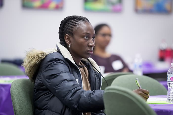 An African-American woman taking notes.