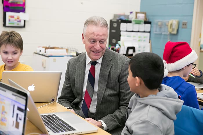 Dr. Martirano talking to a young male student sitting in front of a computer.
