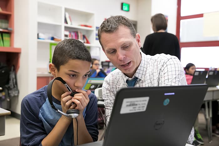 David Floyd looking at a computer with a male student.