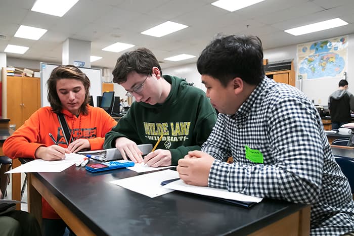 Male South Korean teacher observes HCPSS students doing math.