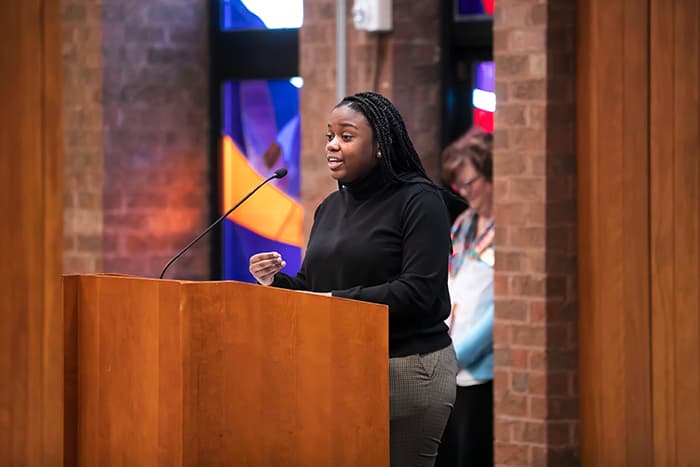 Allison Alston speaking at a podium.