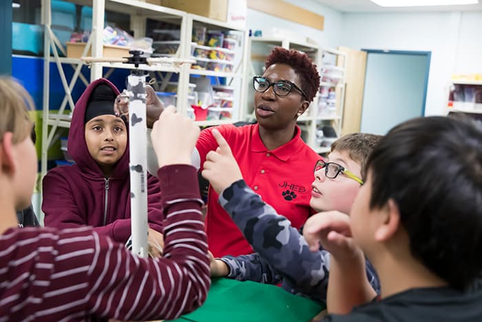 A teacher leads students in an engineering project.