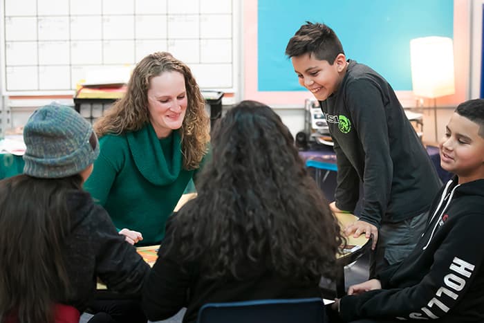 Sarah Mayhew works with a group of students.