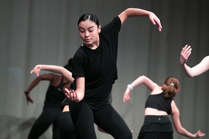 A group of female dancers moving their arms.