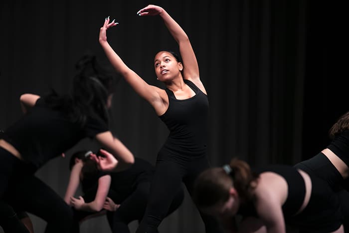 A female dancer with her arms in the air.