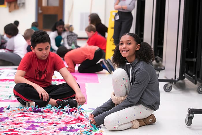 A male and a female student making a blanket.