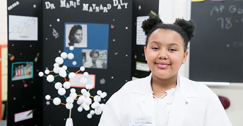 A young African American girl in a science class.