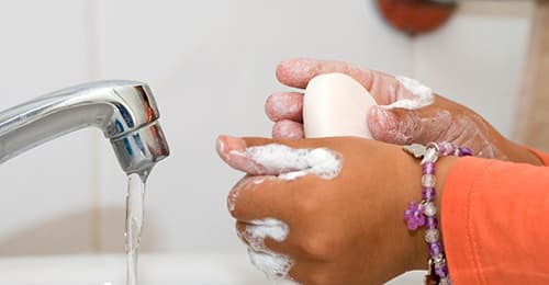 A child's hands holding a bar of soap.