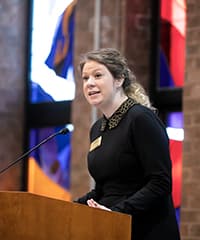 Liz Crammond speaking at a podium.