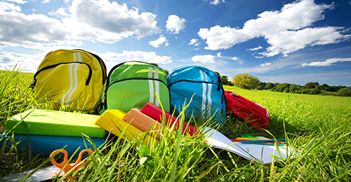 backpacks and school supplies in a field
