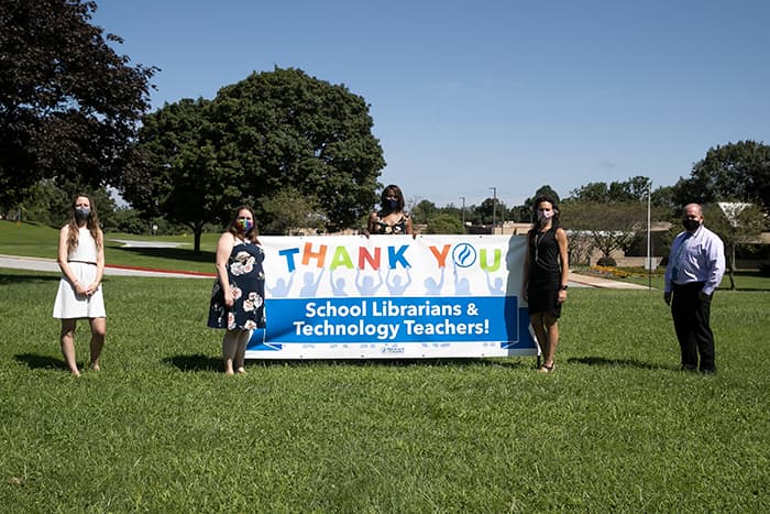 Teachers standing with a thank you school librarians and technology teachers sign.