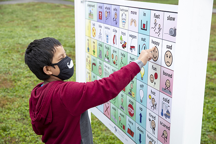 A student points at a sign at the WAVES playground.