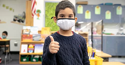 male ES student wearing face mask giving thumbs up