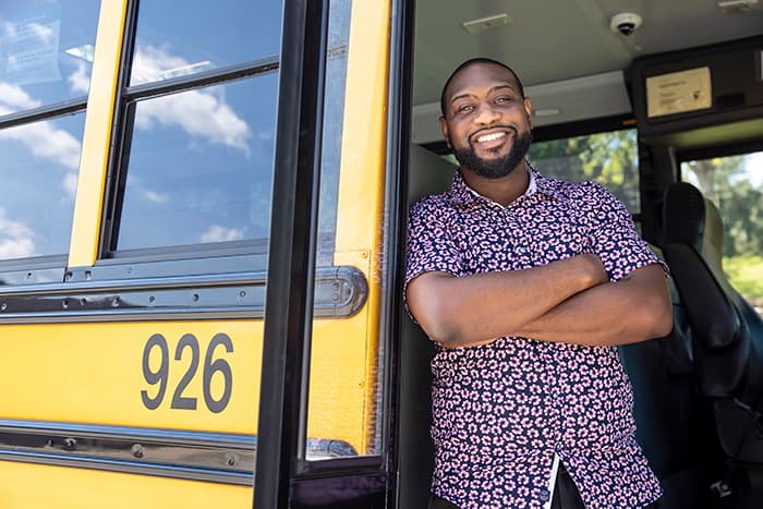 Javion Hinmon stands inside a school bus.