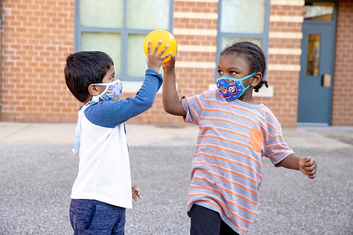 Two male VES pre-K students play ball together.