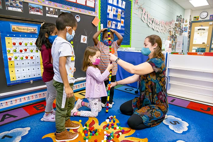 VES special education teacher Casey Beaucage works with students on stacking blocks.
