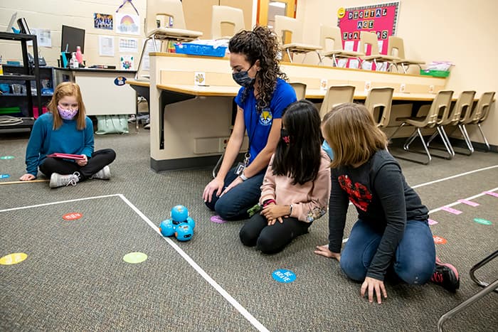 CCES students and Instructional Technology Teacher Rachel Gelinas make a robot move.