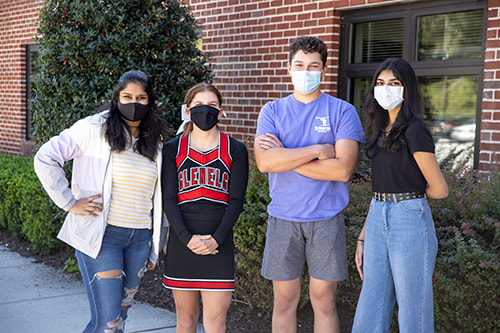A group of four, masked high school students.
