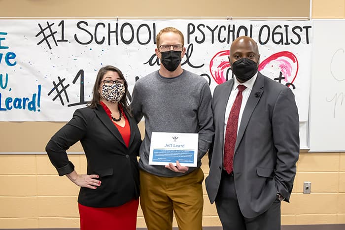 HHES school psychologist Jeff Leard stands with HHES Assistant Principal Shari Lorch and Principal Troy Todd in from of a sign that says #1 School Psychologist.