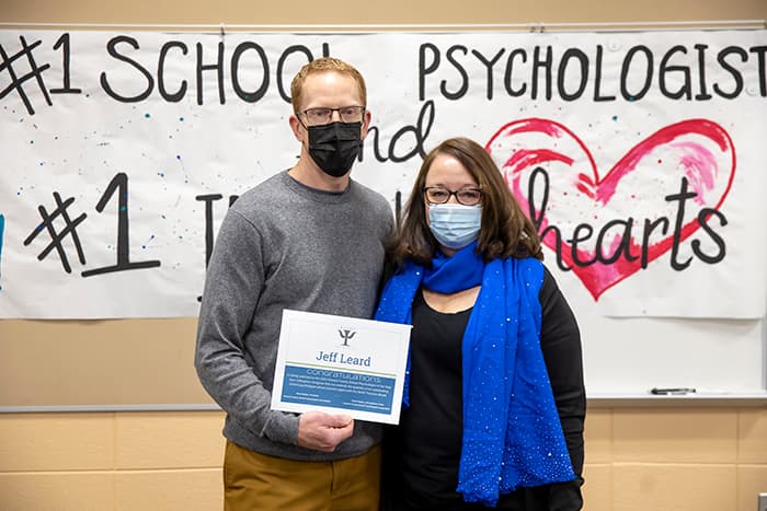 HHES school psychologist Jeff Leard stands with HCSPA President Mary Nalepa in front of a sign that says #1 School Psychologist.