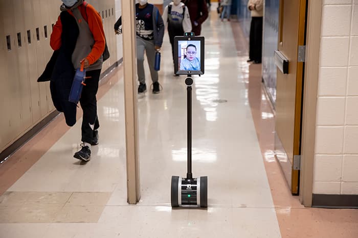 EMMS student Dylan rolls through a hallway using a home and hospital robot.