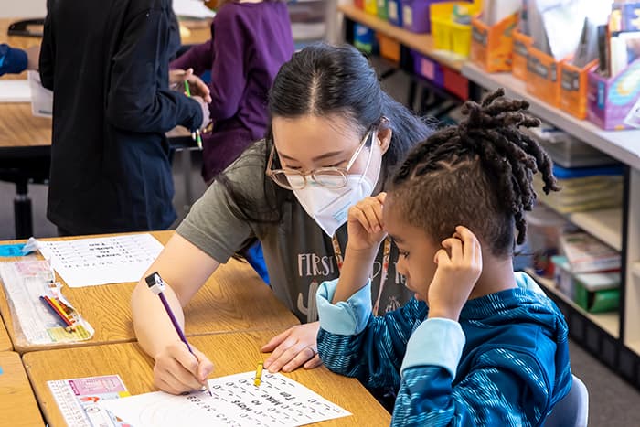 Elkridge Elementary School first-grade teacher Nancy Paik helps a student with math.