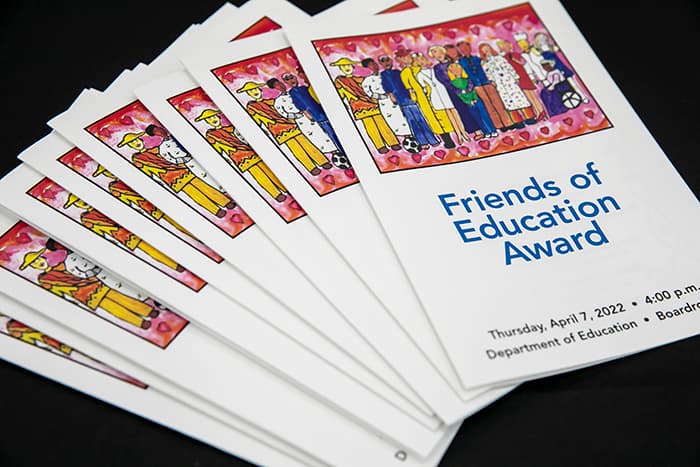 Several copies of the 2022 Friends of Education paper program.